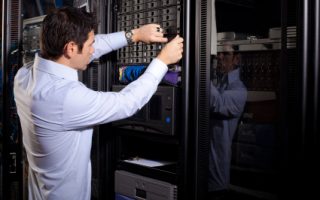 An IT technician is shown repairing data drives on a server network